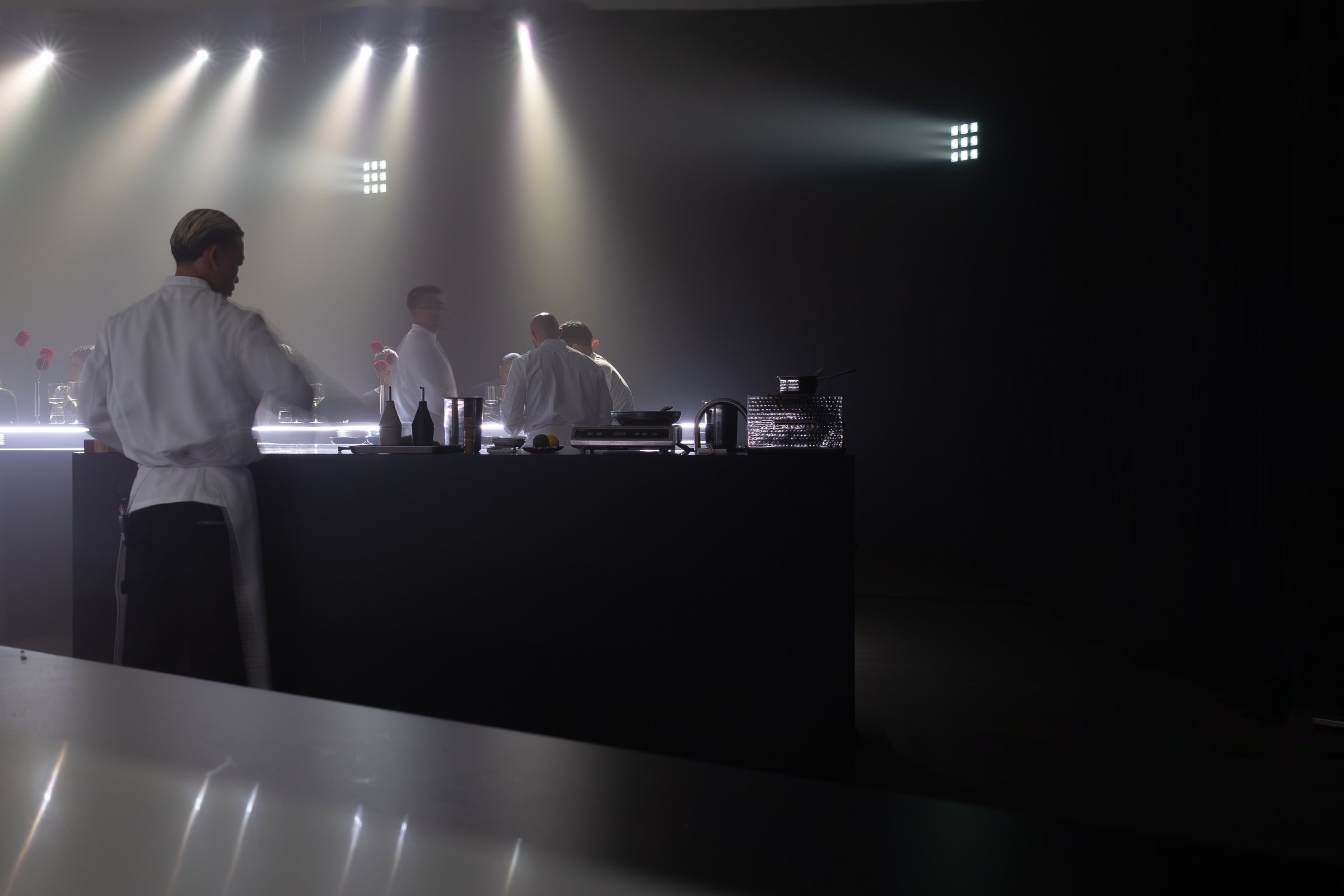 Guests gathered around the curved omakase counter at the Apple TV x Beats Miami Grand Prix dinner, photographed by Alicia Valdez