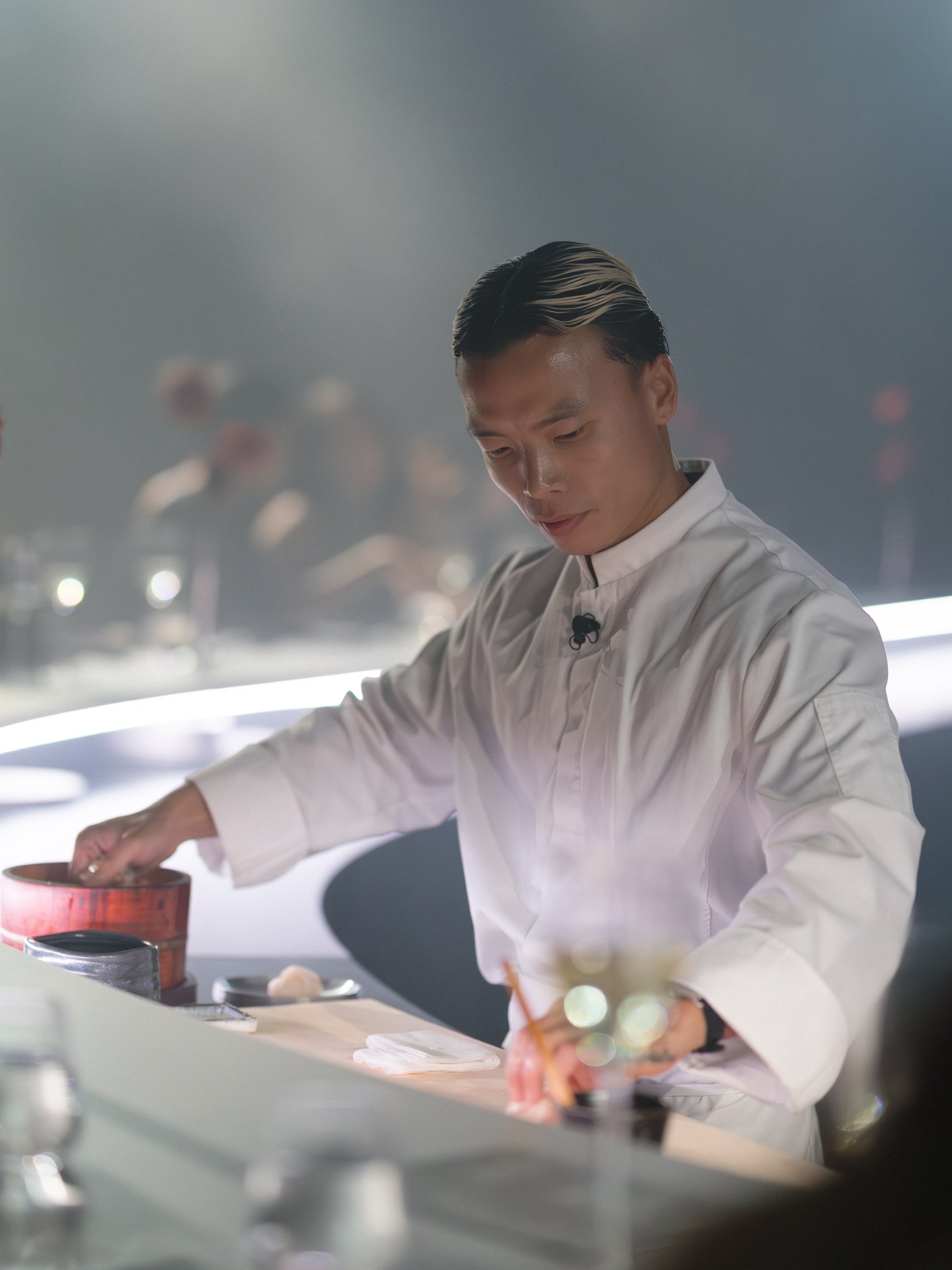 Chef Wei Chen preparing a course at the omakase counter, Apple TV x Beats Miami Grand Prix dinner, by Alicia Valdez