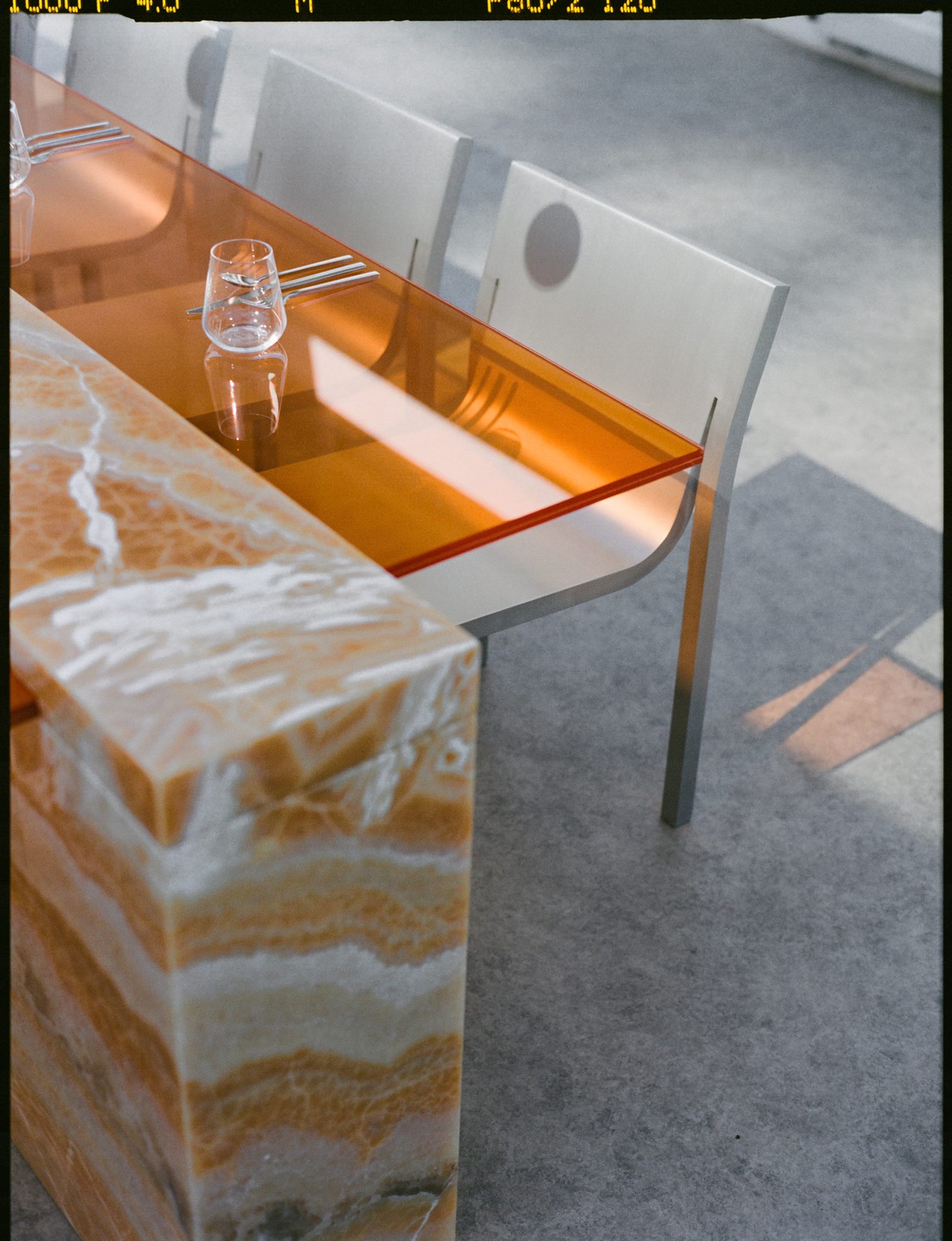 Detail of the amber glass tabletop and banded onyx base in the Sabine Marcelis environment at the We Are Ona Miami Art Week dinner, photographed by Alicia Valdez